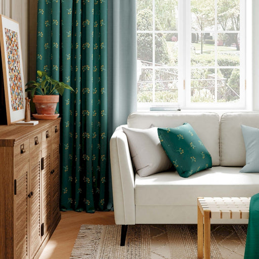 ein Wohnzimmer mit weißem Sofa und grünen Vorhängen