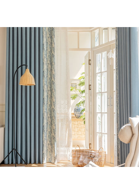 ein Wohnzimmer mit blauen Vorhängen und einem weißen Stuhl