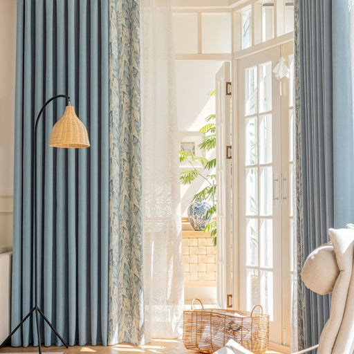 ein Wohnzimmer mit blauen Vorhängen und einem weißen Stuhl