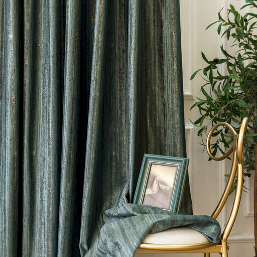 Ein Bilderrahmen steht auf einem Stuhl neben einem Vorhang.