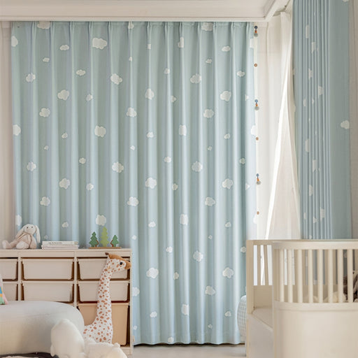 Ein Babyzimmer mit blauen Vorhängen und einem weißen Kinderbett