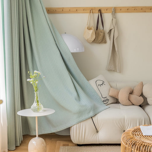 ein Wohnzimmer mit einem weißen Sofa und einem grünen Vorhang