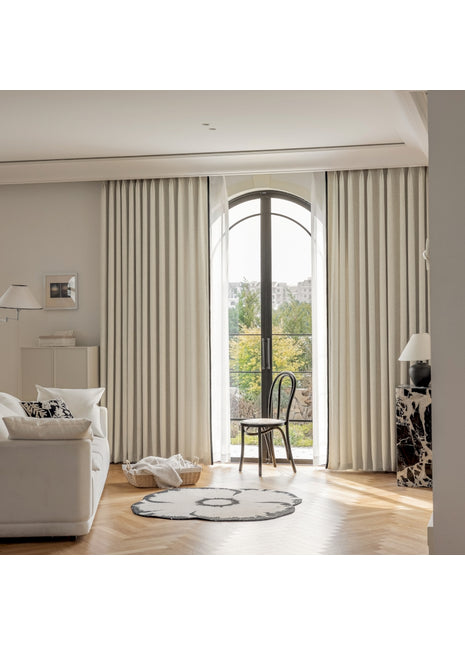 ein Wohnzimmer mit einem weißen Sofa, einem Sessel und einem Fenster