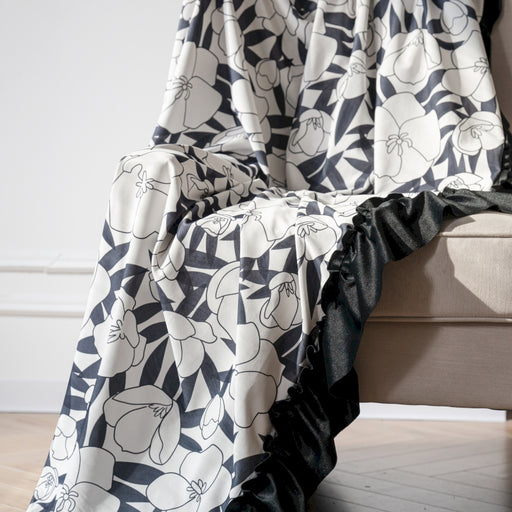 a black and white blanket sitting on top of a couch