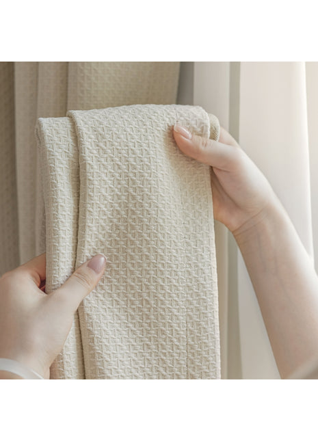 Eine Person, die ein weißes Handtuch vor einem Fenster hält
