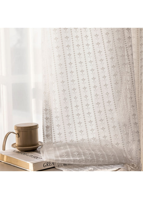 Eine Kaffeetasse steht auf einem Buch neben einem Fenster.