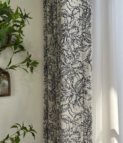 Neben einem Vorhang hängt eine Pflanze an der Wand.