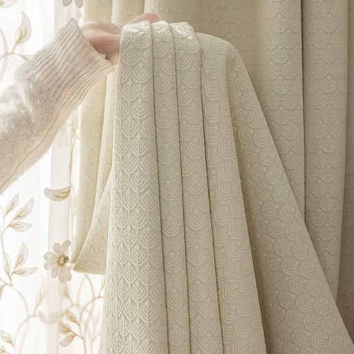 Eine Person hält einen Vorhang vor ein Fenster