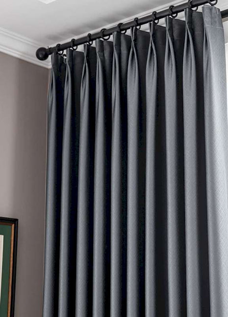 a window with a black curtain and a picture on the wall