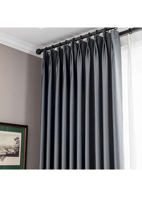 ein Fenster mit einem schwarzen Vorhang und einem Bild an der Wand