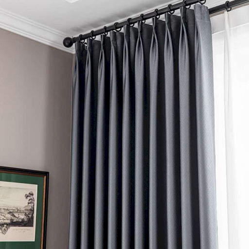 ein Fenster mit einem schwarzen Vorhang und einem Bild an der Wand