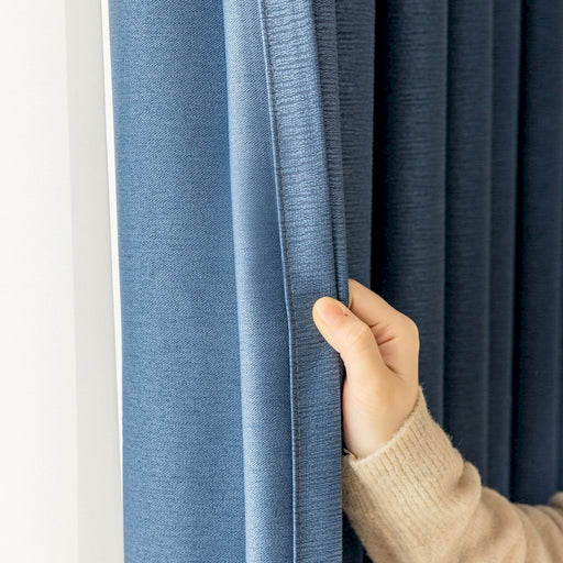 a person is opening the curtain with their hand