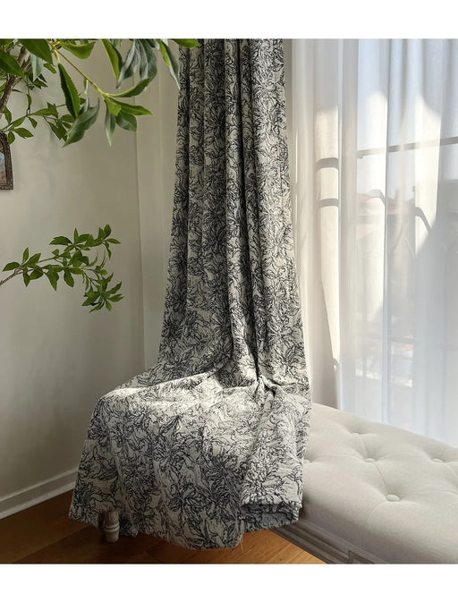 Ein weißes Sofa steht unter einem Fenster neben einer Pflanze.