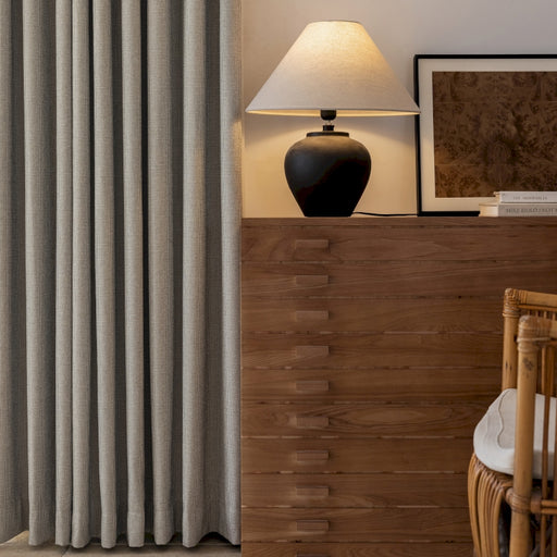 ein Wohnzimmer mit einer Lampe, einem Stuhl und einem Fenster