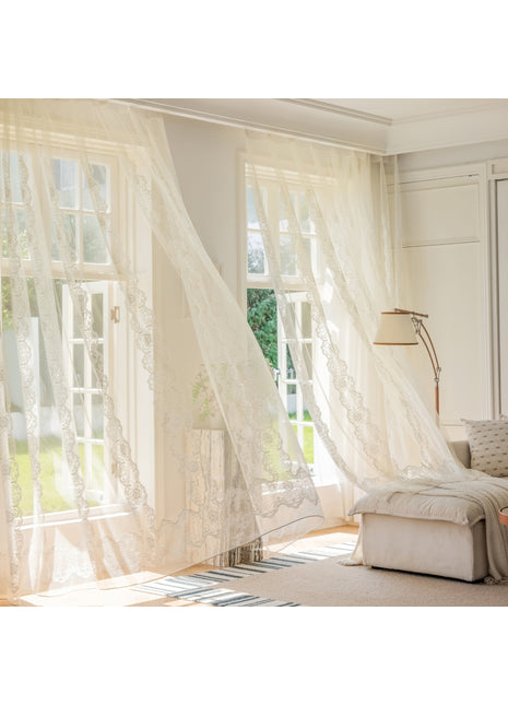 ein Wohnzimmer mit weißen Vorhängen und einem Sofa