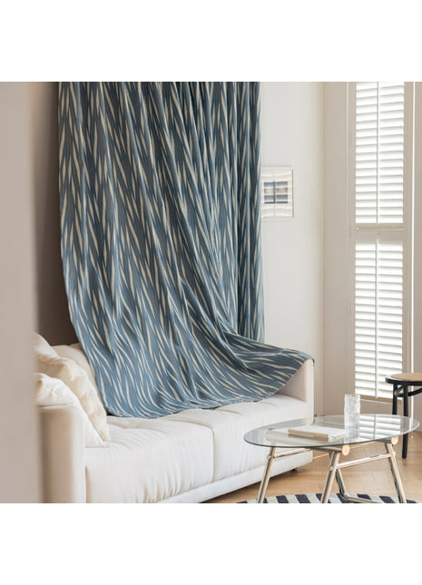 ein Wohnzimmer mit einem weißen Sofa und einem blauen Vorhang