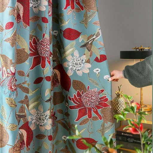 Eine Person öffnet einen Vorhang mit Blumenmuster