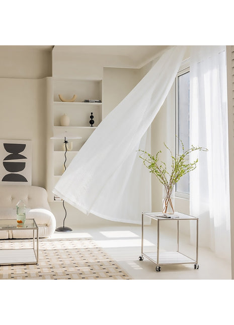 ein Wohnzimmer mit weißem Sofa und weißen Vorhängen