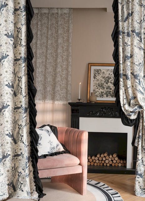 a living room with a pink chair and a fireplace