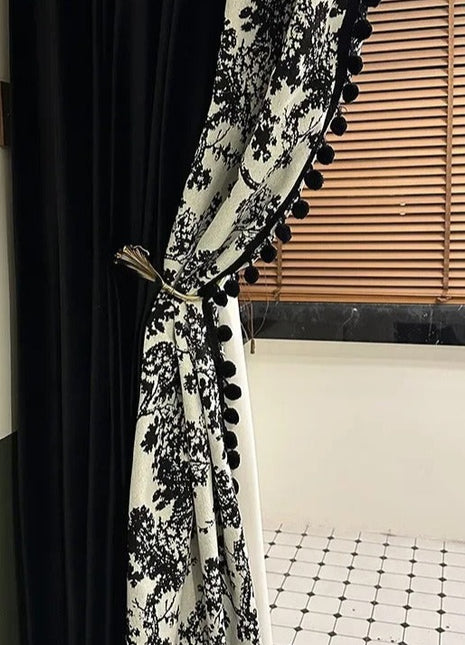 a black and white curtain with pom pom trim