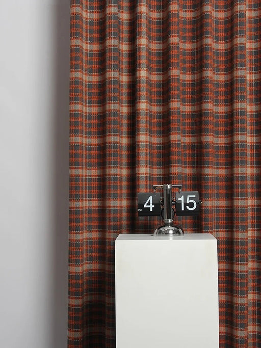 Eine Uhr auf einem Sockel vor einem Vorhang