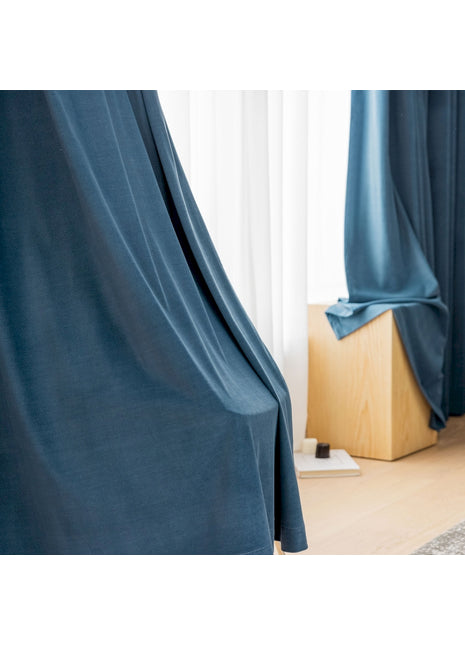 ein Zimmer mit einem blauen Vorhang und einem Holzboden