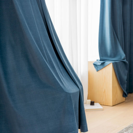 ein Zimmer mit einem blauen Vorhang und einem Holzboden