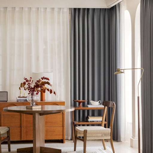 ein Wohnzimmer mit einem Tisch, einem Stuhl und einem Fenster