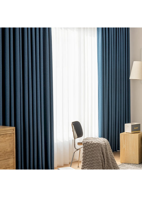 ein Schlafzimmer mit blauen Vorhängen und einem Bett