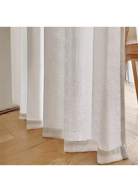Nahaufnahme eines Vorhangs mit einem Stuhl im Hintergrund