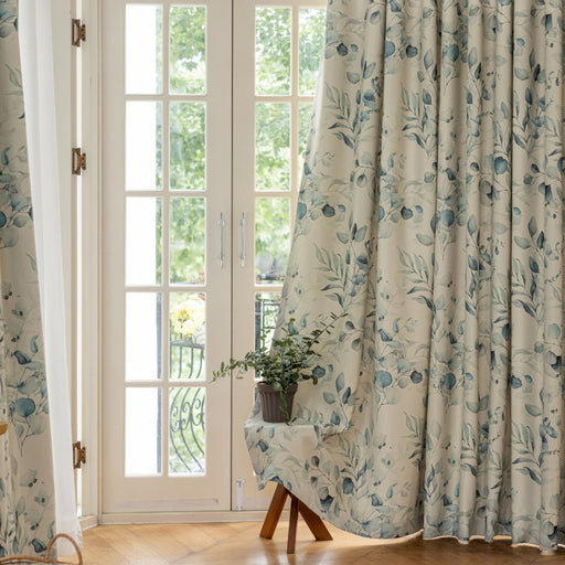 Ein Stuhl vor einem mit Vorhängen verhängten Fenster