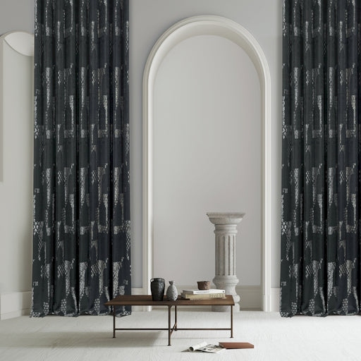 ein Wohnzimmer mit einem Tisch und zwei schwarzen Vorhängen