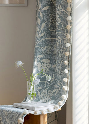 a vase with a flower on a table next to a window