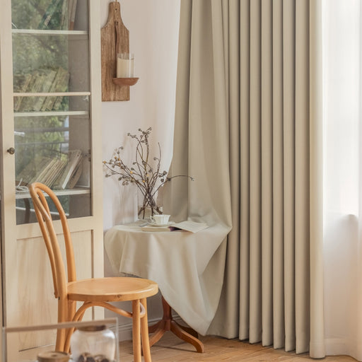 ein Zimmer mit einem Stuhl, einem Tisch und einem Fenster