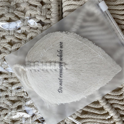 Attache Rideau Corde. Un sac en macramé blanc avec un gland blanc, parfait pour ajouter une touche déco à vos rideaux.